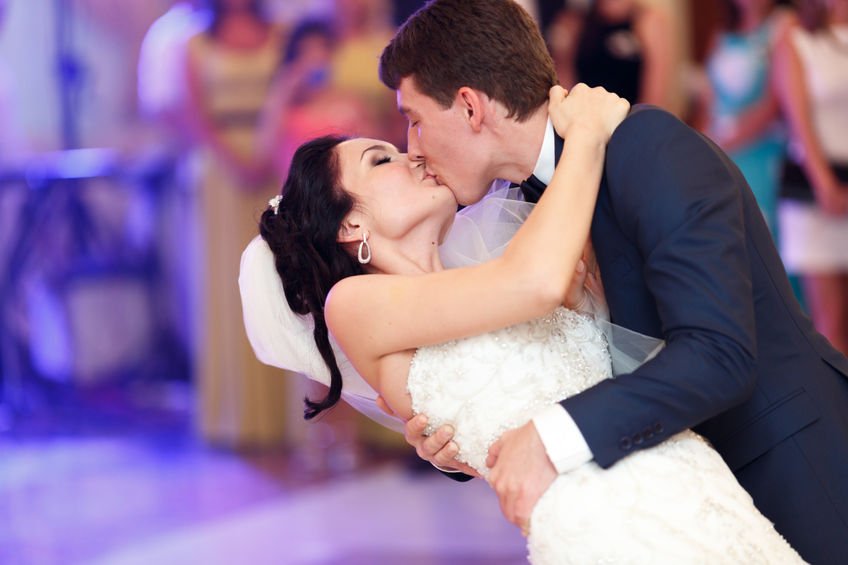 Groom Kisses Bride During First Dance at Wedding Reception